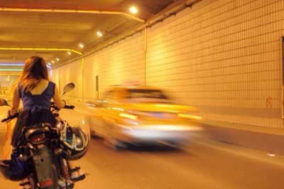 Blurred motion of woman on city street at night