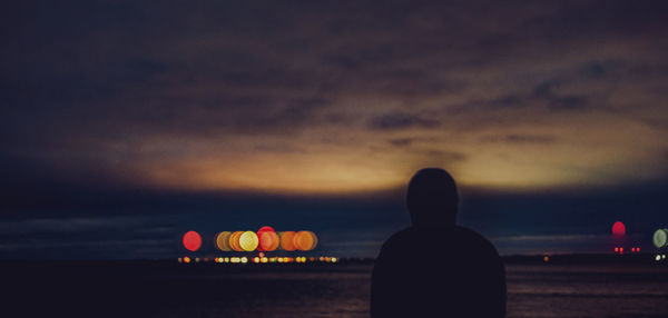 Rear view of silhouette person tanding against sky during sunset