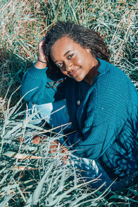 Portrait of smiling young woman sitting on grassy land