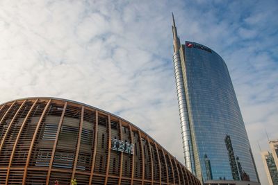 Low angle view of modern building against cloudy sky