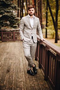 Portrait of businessman standing against trees