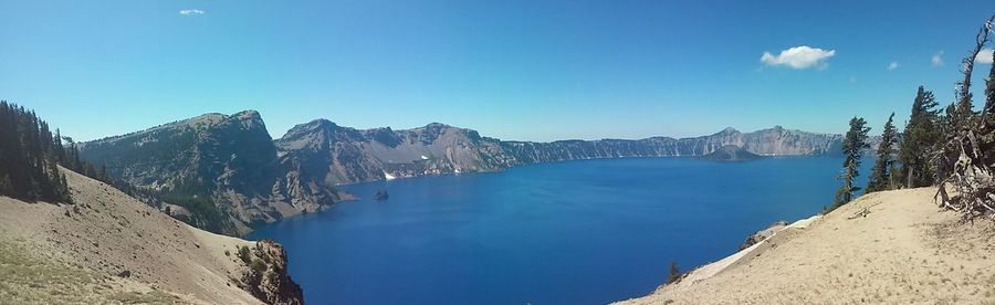 Panoramic view of sea and mountains against clear blue sky