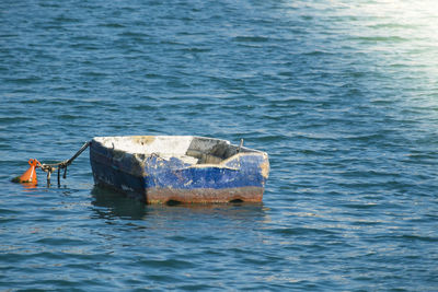 Damaged boat moored in sea