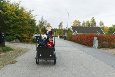 Mother and children having ride with cargo bike