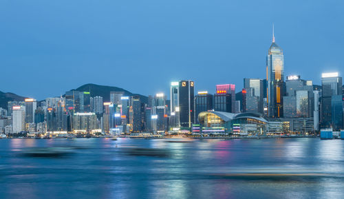 Illuminated buildings in city at waterfront