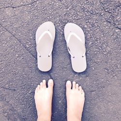 Low section of woman with flip-flops standing on street