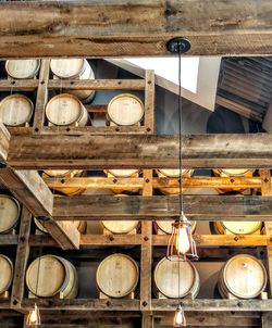 Low angle view of wine casks on shelves in cellar