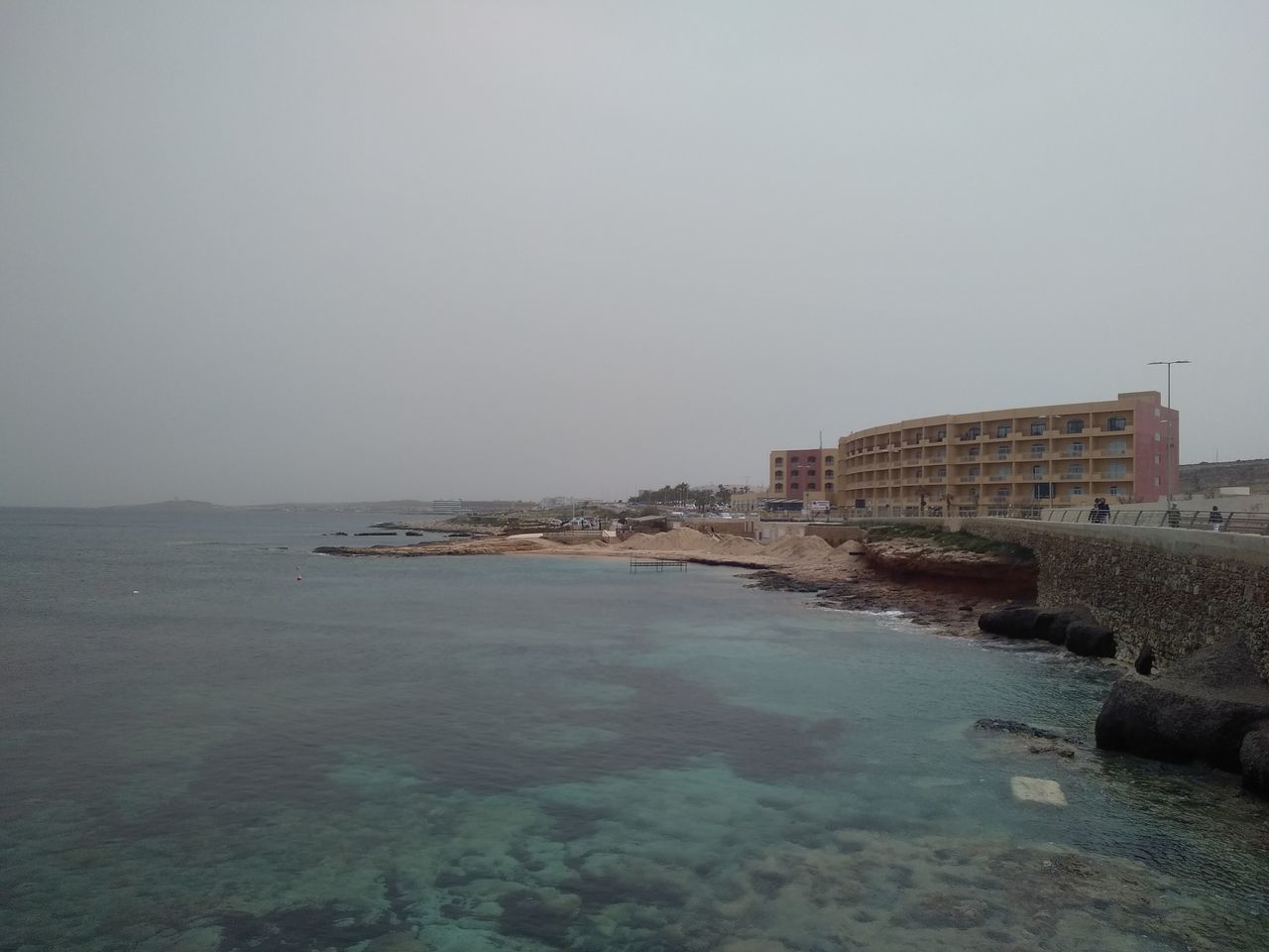 SCENIC VIEW OF SEA AND BUILDING AGAINST CLEAR SKY