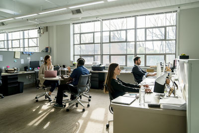 Business people discussing while sitting at desk in office