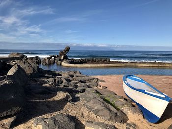 Scenic view of rocks on beach against sky