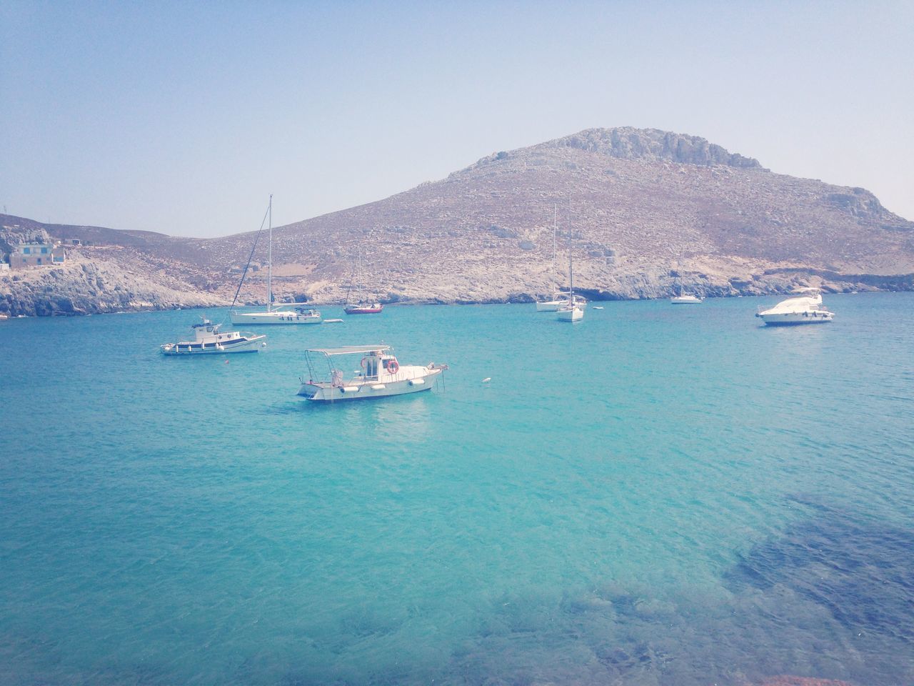 nautical vessel, mountain, water, transportation, boat, mode of transport, sea, waterfront, mountain range, scenics, tranquil scene, tranquility, beauty in nature, clear sky, nature, moored, rippled, sky, travel, day