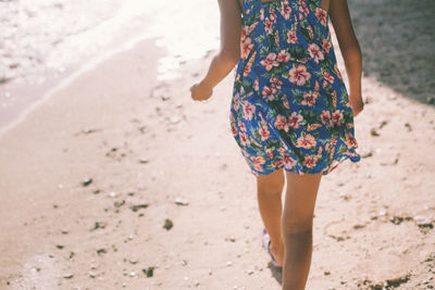 Rear view of woman walking on beach