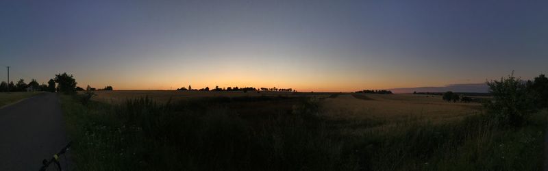 Panoramic shot of field against clear sky during sunset