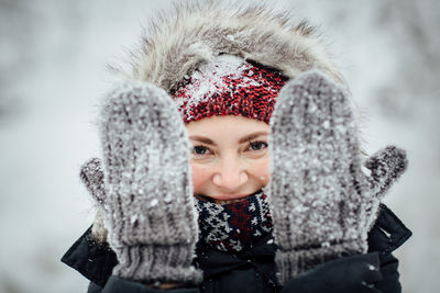 Portrait of smiling woman wearing gloves during winter