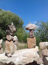 Stone stack on rock against sky