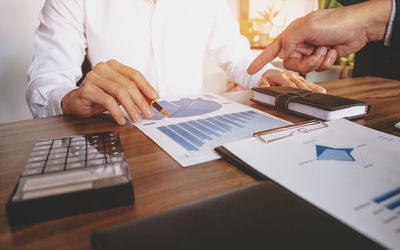 Midsection of man using laptop on table
