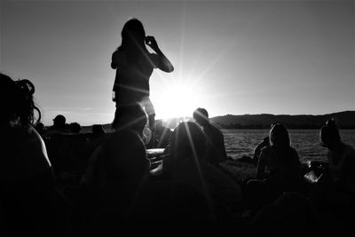 People at beach against clear sky