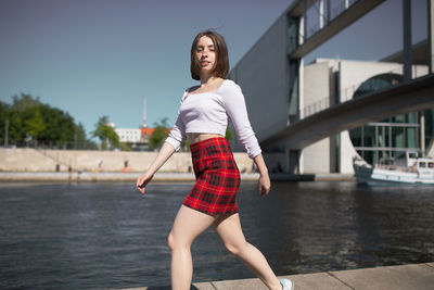 Full length portrait of young woman standing in water