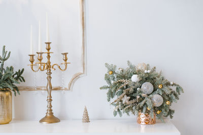 Christmas decor in a classic living room or bedroom in bright colors. spruce branches in gold vases