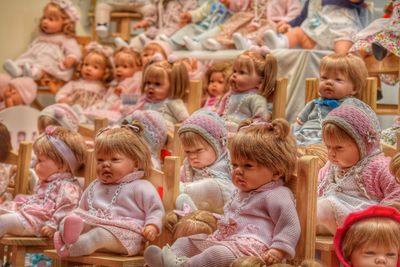 Close-up of dolls on chairs at store