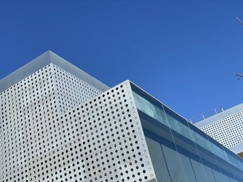 Low angle view of modern building against clear blue sky