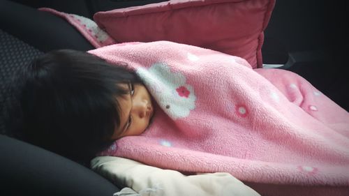 Close-up of baby girl on bed