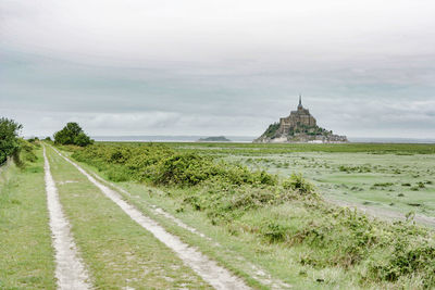 Road leading towards temple against sky