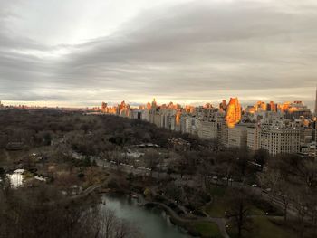 High angle view of buildings and river against sky during sunset