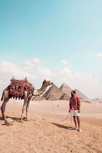 Full length of men walking on desert against sky