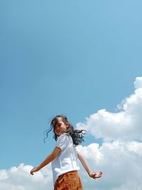 Low angle view of woman standing against sky