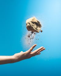 Close-up of hand against blue background