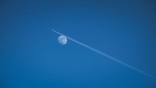 Low angle view of vapor trail against clear blue sky
