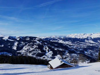 Scenic view of snowcapped mountains against blue sky