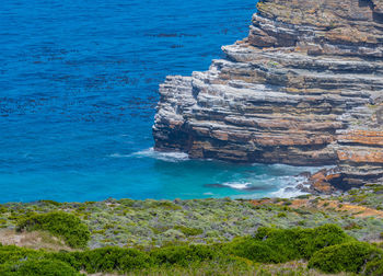 Steep cliffs and turquoise sea at the cape of good hope in south africa