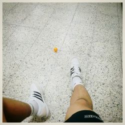 Low section of man standing on tiled floor