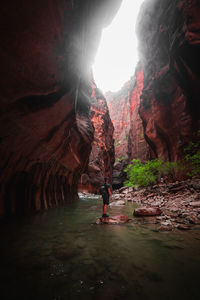 People on rock formation in water