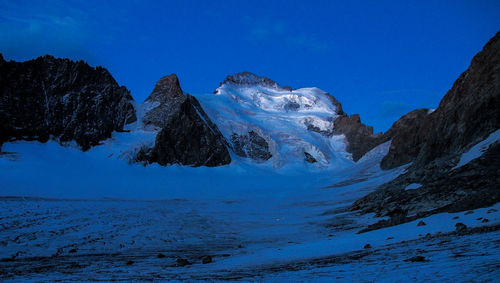 Scenic view of snowcapped mountains against clear blue sky