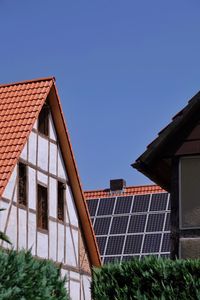 Low angle view of house roof against blue sky