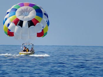 Colorful parasail in sea against clear sky