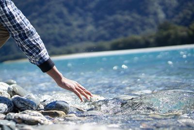 Close-up of man touching water