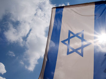 Low angle view of flag against blue sky