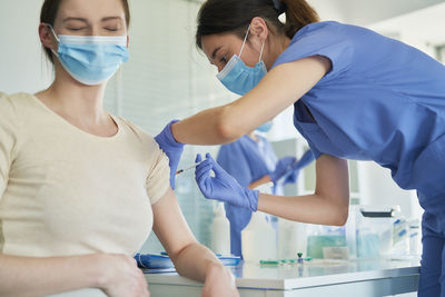 Doctor giving vaccination to patient in hospital