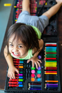 High angle view portrait of angry girl on art and craft equipment