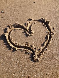 High angle view of heart shape on sand