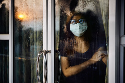 Portrait of man looking through window