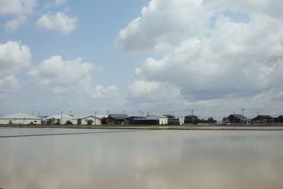 Reflection of building in lake against sky