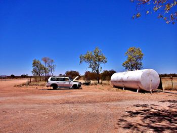 Cars on road against clear blue sky