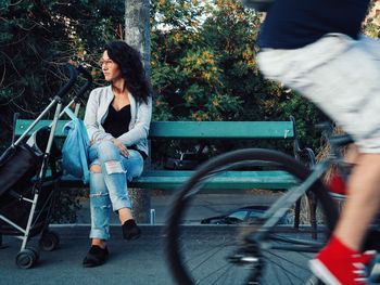 Man cycling past woman