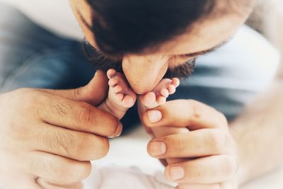 Close-up of father kissing legs of baby