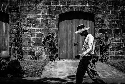 Side view of man walking by old building